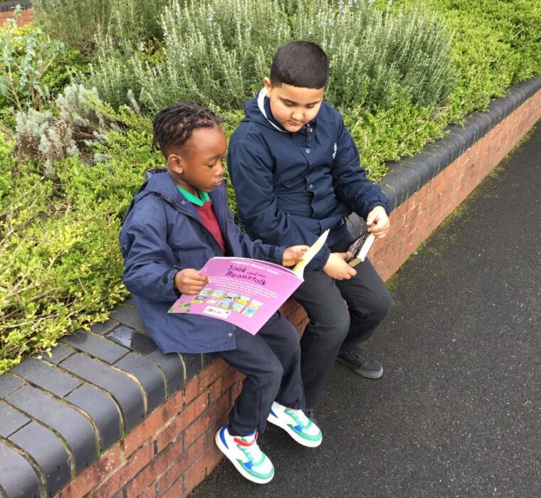 Two Pupils Reading Books Outside