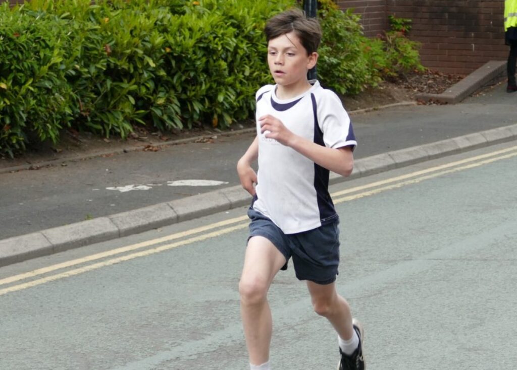 Prep School Pupil Competing In A Road Running Race